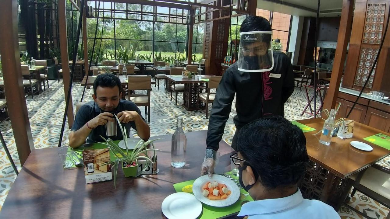 The Orchid Hotel Hinjewadi Pune Extérieur photo A restaurant in India with a waiter wearing a face shield